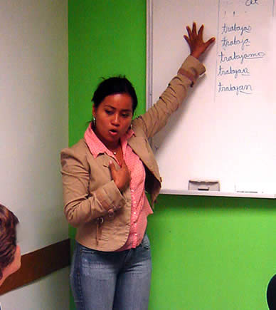 Spanish teacher in classroom in front of whiteboard explaining a lesson